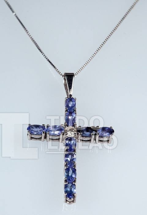 Cruz com 10 tanzanitas ovais e aproximadamente 2.5ct e 1 diamante no centro de 0.20ct