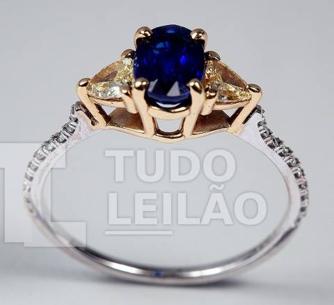 Anel bicolor em ouro 18k, com safira azul de 1 ct e brilhantes Fancy Yellow com muita vida, de aproximadamente 0,15 ct cada. Aro: 17
