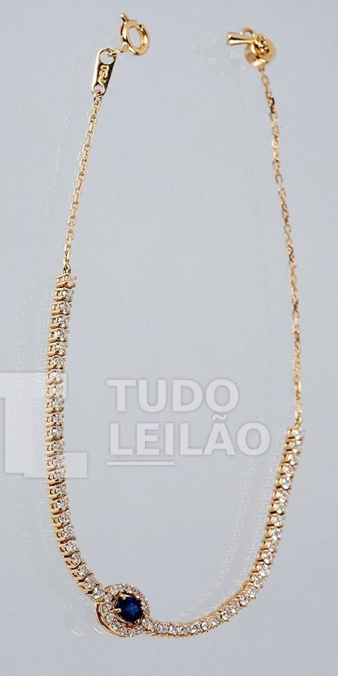 Pulseira Riviera em ouro amarelo 18k, com safira central de 0,15 cts e 62 diamantes totalizando aproximadamente 0,35 cts