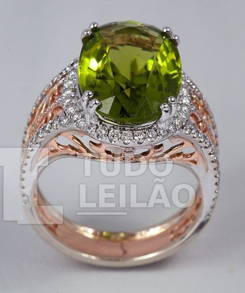 Anel em ouro branco e rosé, com peridoto verde oval de aproximadamente 14,80 mm x 10,30 mm, cercado por diamantes redondos. Aro: 17